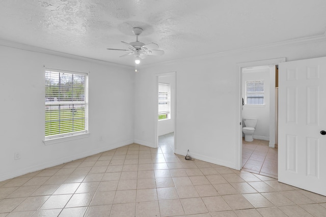 unfurnished room featuring a textured ceiling, ceiling fan, ornamental molding, and light tile patterned flooring