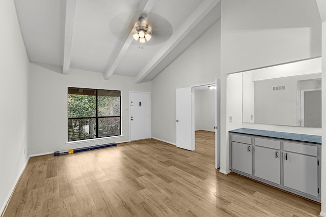 unfurnished living room featuring beam ceiling, ceiling fan, high vaulted ceiling, and light hardwood / wood-style floors