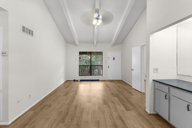 unfurnished living room with ceiling fan, beam ceiling, and light wood-type flooring