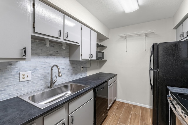 kitchen featuring backsplash, black appliances, white cabinets, sink, and light wood-type flooring