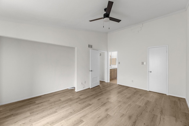 unfurnished bedroom featuring a high ceiling, ceiling fan, ornamental molding, connected bathroom, and light hardwood / wood-style floors