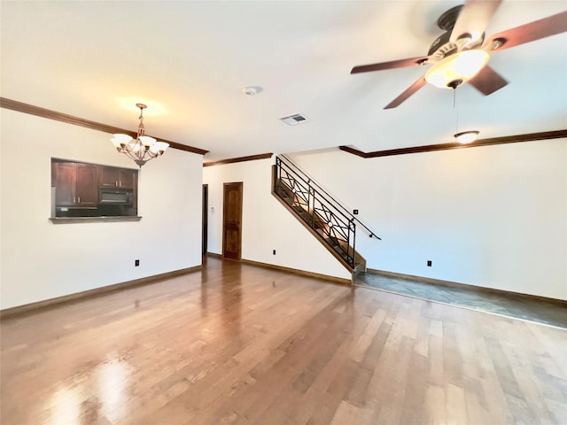 unfurnished living room featuring crown molding, ceiling fan with notable chandelier, and hardwood / wood-style flooring