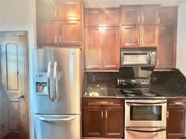 kitchen with appliances with stainless steel finishes, backsplash, and dark stone countertops