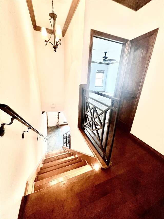 stairway with ceiling fan with notable chandelier and ornamental molding