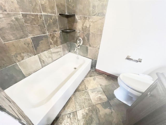 bathroom featuring toilet and tiled shower / bath