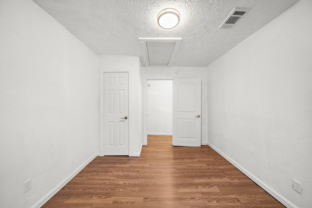 unfurnished room featuring wood-type flooring and a textured ceiling