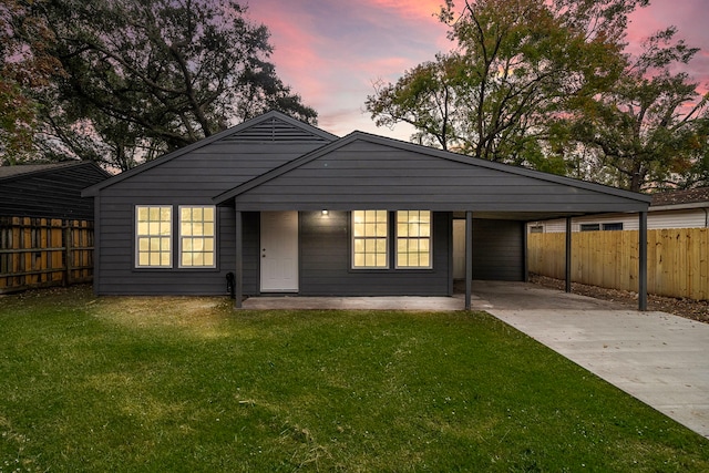 view of front of property with a carport and a lawn