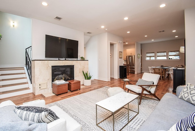 living room with light wood-type flooring and a premium fireplace