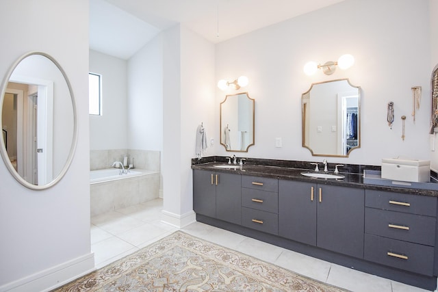 bathroom with tiled bath, tile patterned flooring, and vanity