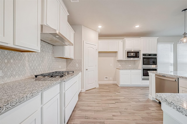 kitchen with pendant lighting, light stone countertops, white cabinetry, stainless steel appliances, and extractor fan