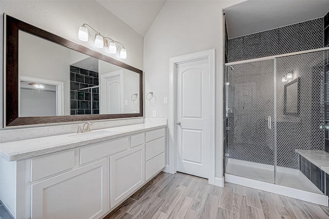 bathroom featuring vanity, walk in shower, and lofted ceiling