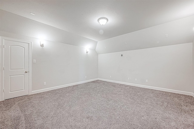 carpeted empty room with lofted ceiling