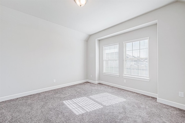 empty room featuring carpet floors and vaulted ceiling