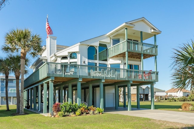 rear view of property with a lawn, a garage, and a carport