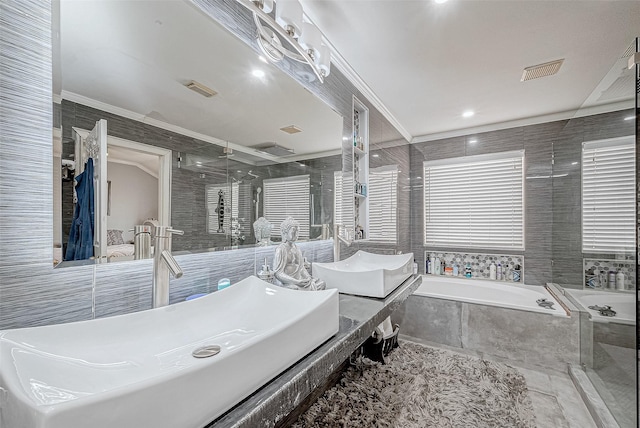 bathroom featuring vanity, tiled bath, tile walls, and crown molding