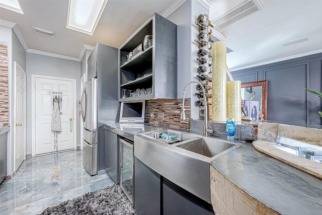 kitchen with stainless steel counters, ornamental molding, and tasteful backsplash