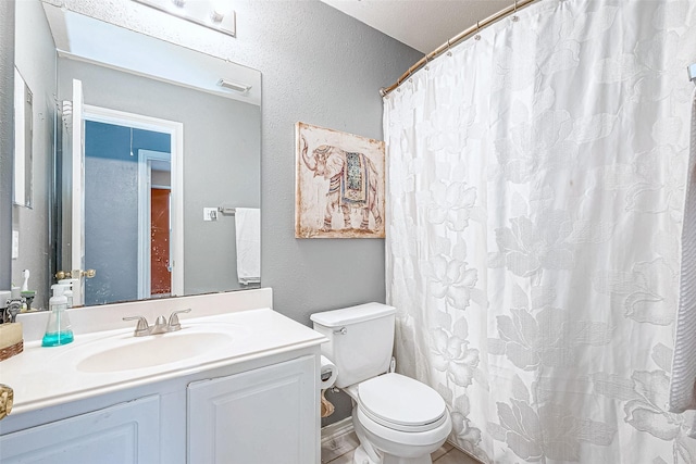 bathroom with a shower with shower curtain, vanity, toilet, and a textured ceiling