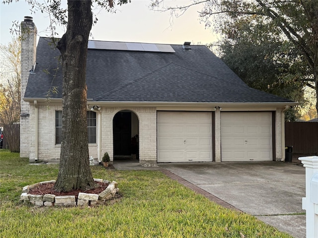 view of front of house featuring solar panels, a garage, and a front yard