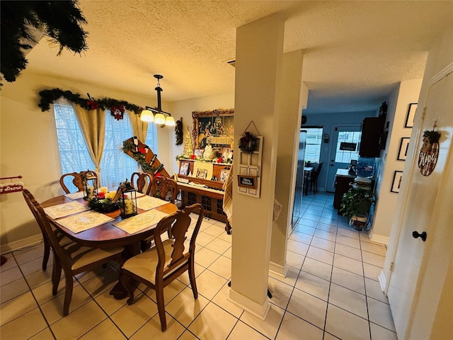 dining area featuring light tile patterned flooring and a textured ceiling