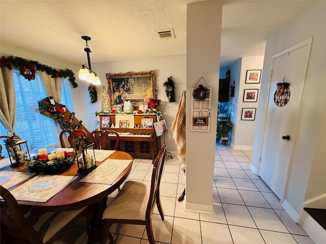 tiled dining area featuring a textured ceiling