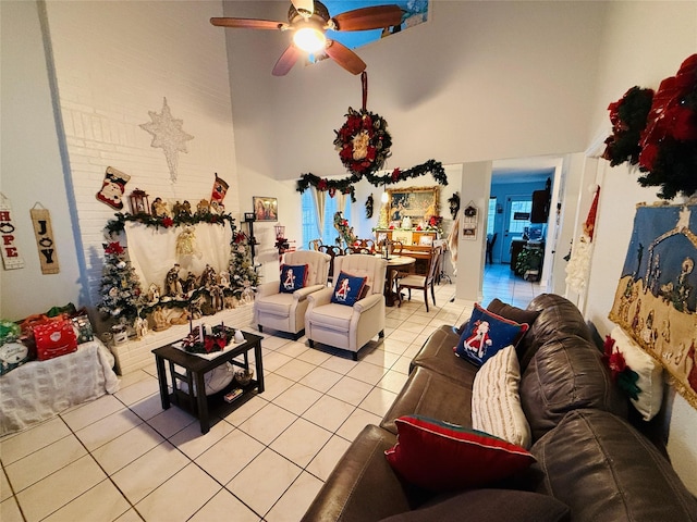 living room with ceiling fan, light tile patterned floors, and a high ceiling