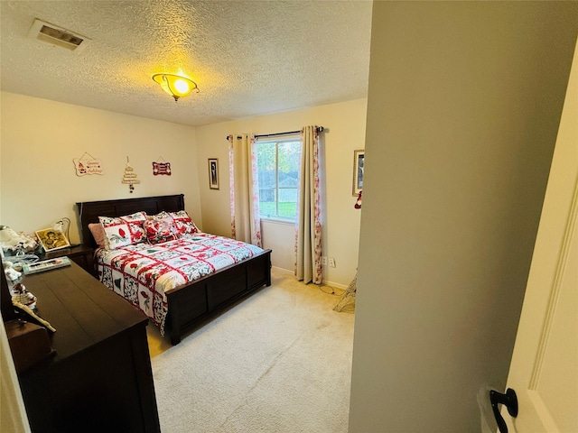 bedroom with light carpet and a textured ceiling