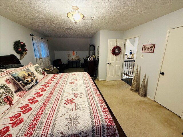 bedroom featuring light colored carpet and a textured ceiling