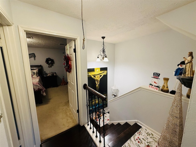 stairs with carpet flooring and a textured ceiling