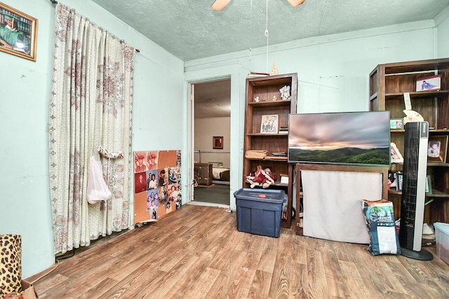 interior space featuring a textured ceiling, hardwood / wood-style flooring, and ceiling fan