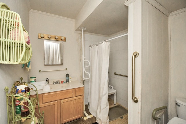 bathroom featuring toilet, vanity, ornamental molding, and walk in shower