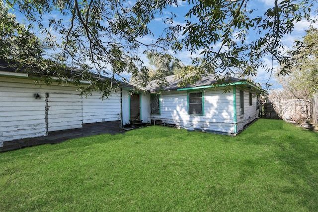 rear view of property featuring a lawn