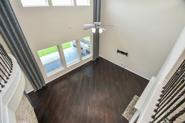 unfurnished living room featuring dark hardwood / wood-style floors and ceiling fan