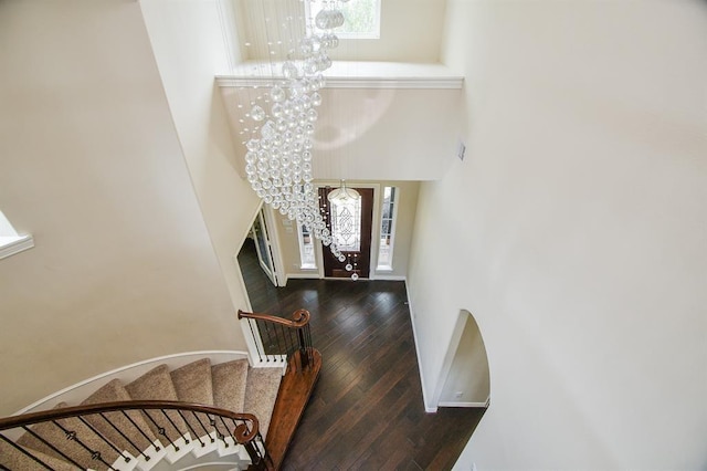 stairway featuring hardwood / wood-style flooring and an inviting chandelier