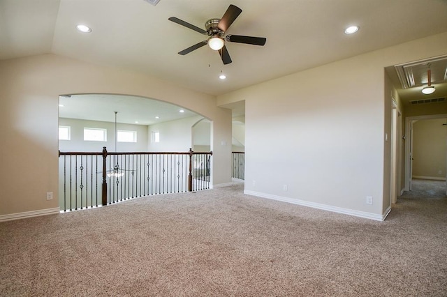 carpeted spare room with ceiling fan and vaulted ceiling