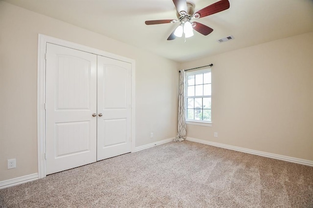 unfurnished bedroom with carpet floors, a closet, and ceiling fan