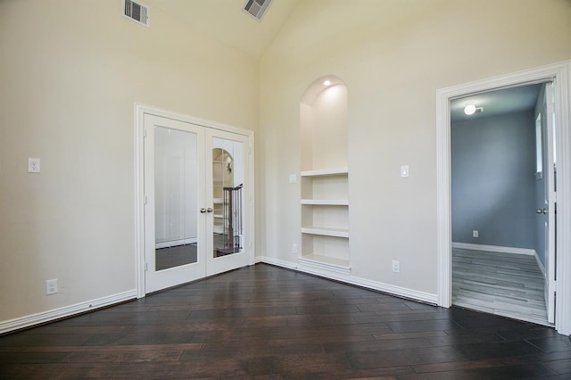 unfurnished living room with built in features, high vaulted ceiling, dark wood-type flooring, and french doors