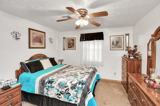 bedroom featuring ceiling fan, light colored carpet, and a textured ceiling