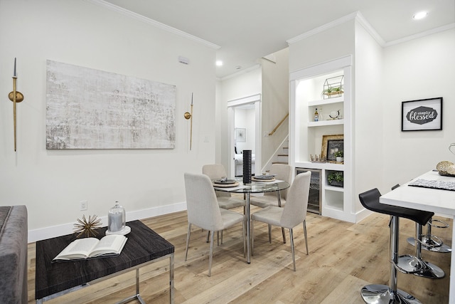 dining space with light wood-type flooring, wine cooler, and crown molding