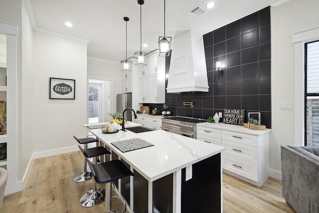 kitchen featuring plenty of natural light, sink, decorative light fixtures, and custom exhaust hood