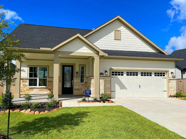 craftsman inspired home featuring a front lawn, a porch, and a garage