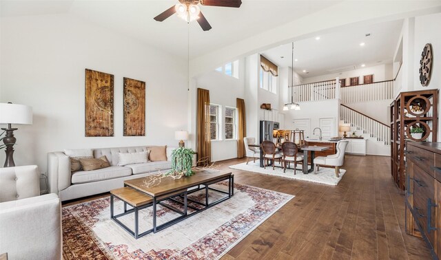 living room with ceiling fan, dark hardwood / wood-style flooring, high vaulted ceiling, and sink