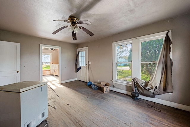 misc room with ceiling fan, wood-type flooring, and a textured ceiling