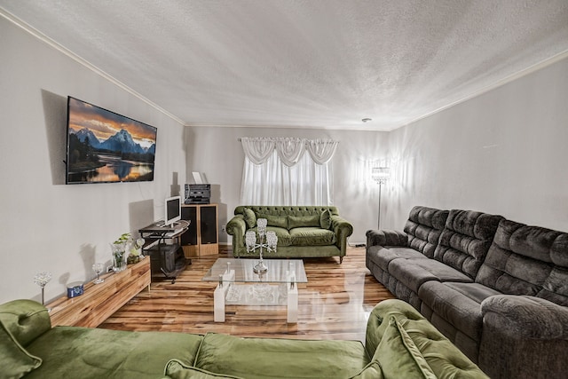 living room with ornamental molding, a textured ceiling, and hardwood / wood-style flooring