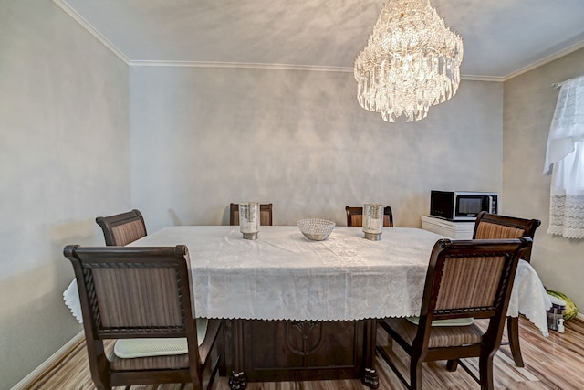 dining area featuring an inviting chandelier, light hardwood / wood-style flooring, and crown molding