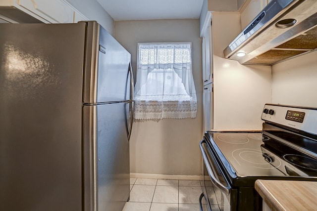 kitchen featuring ventilation hood, electric stove, stainless steel fridge, light tile patterned floors, and white cabinetry