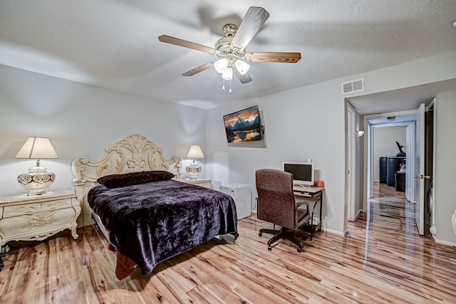 bedroom featuring a textured ceiling, light hardwood / wood-style flooring, and ceiling fan