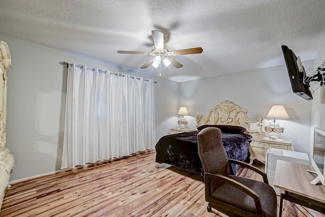 bedroom with ceiling fan, light hardwood / wood-style floors, and a textured ceiling