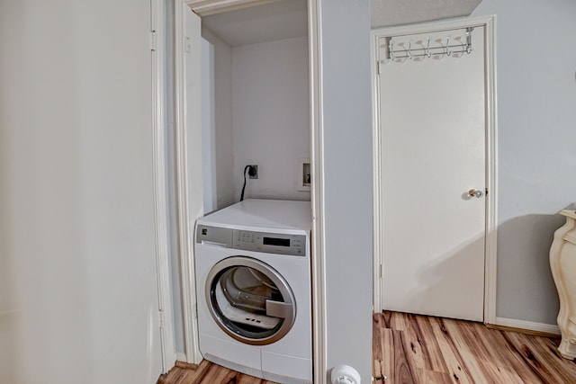 laundry room with washer / dryer and light hardwood / wood-style floors