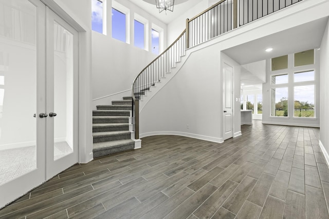 entrance foyer with plenty of natural light, dark hardwood / wood-style floors, a high ceiling, and an inviting chandelier