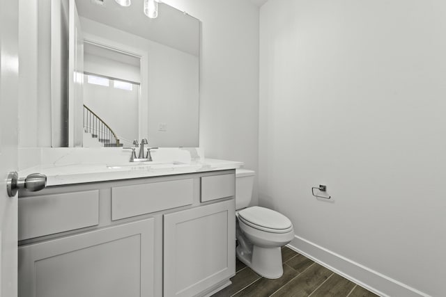 bathroom with hardwood / wood-style floors, vanity, and toilet